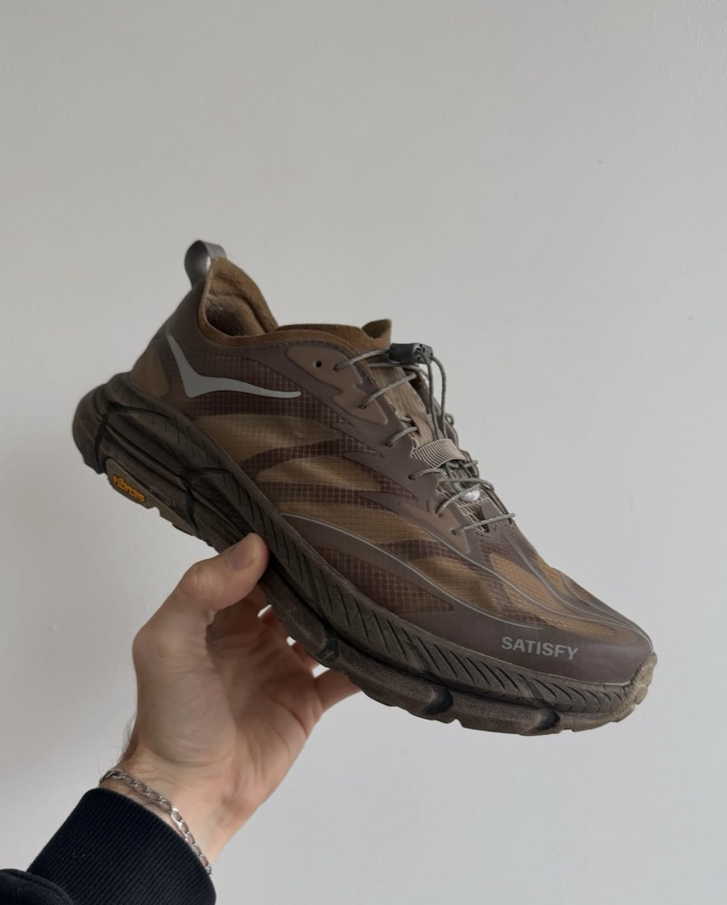 Brown trail sneakers with a SATISFY logo and Vibram sole